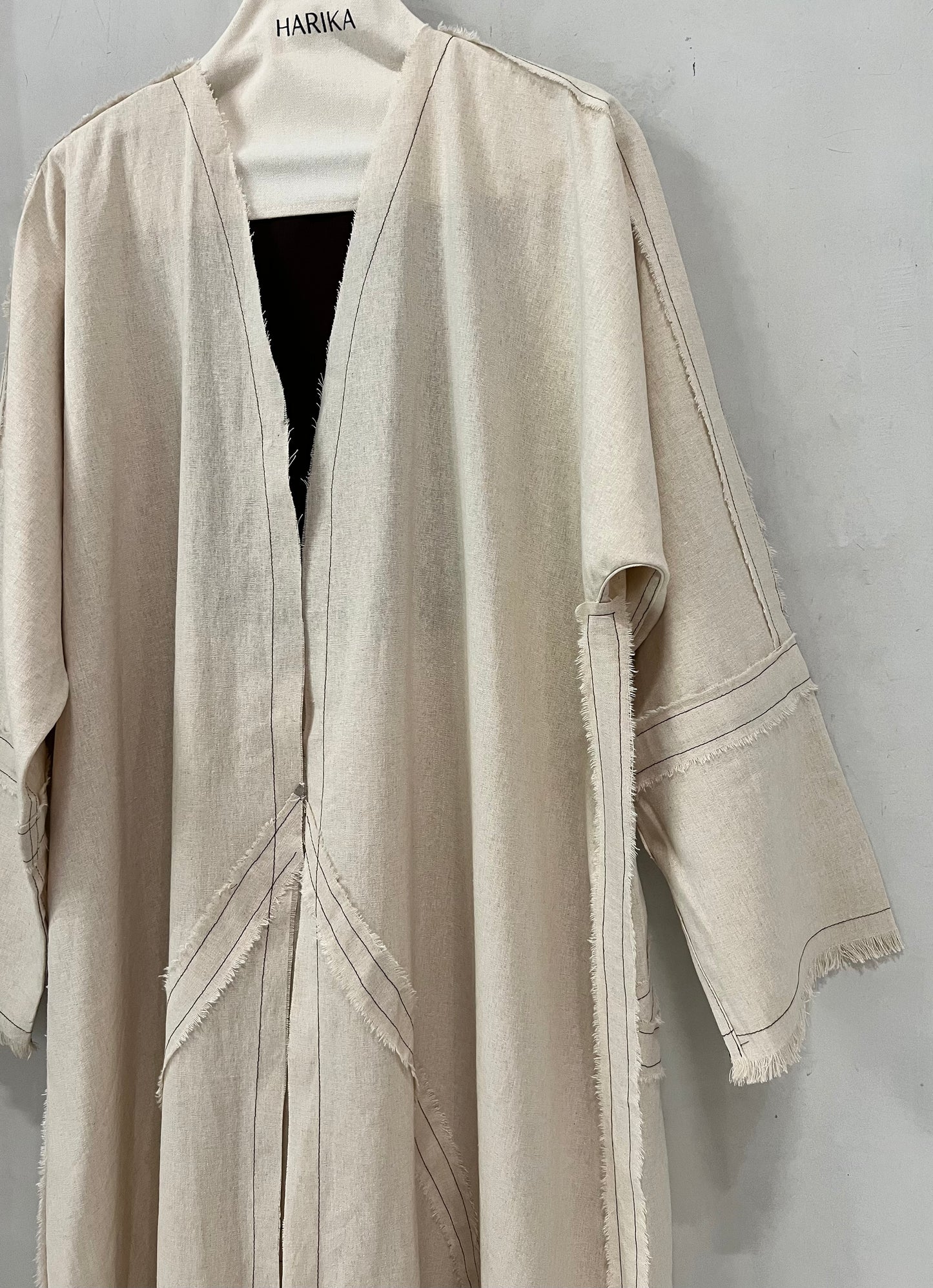 Abaya - Soft natural beige tone, delicate contrast stitching and subtle raw-edge detailing
