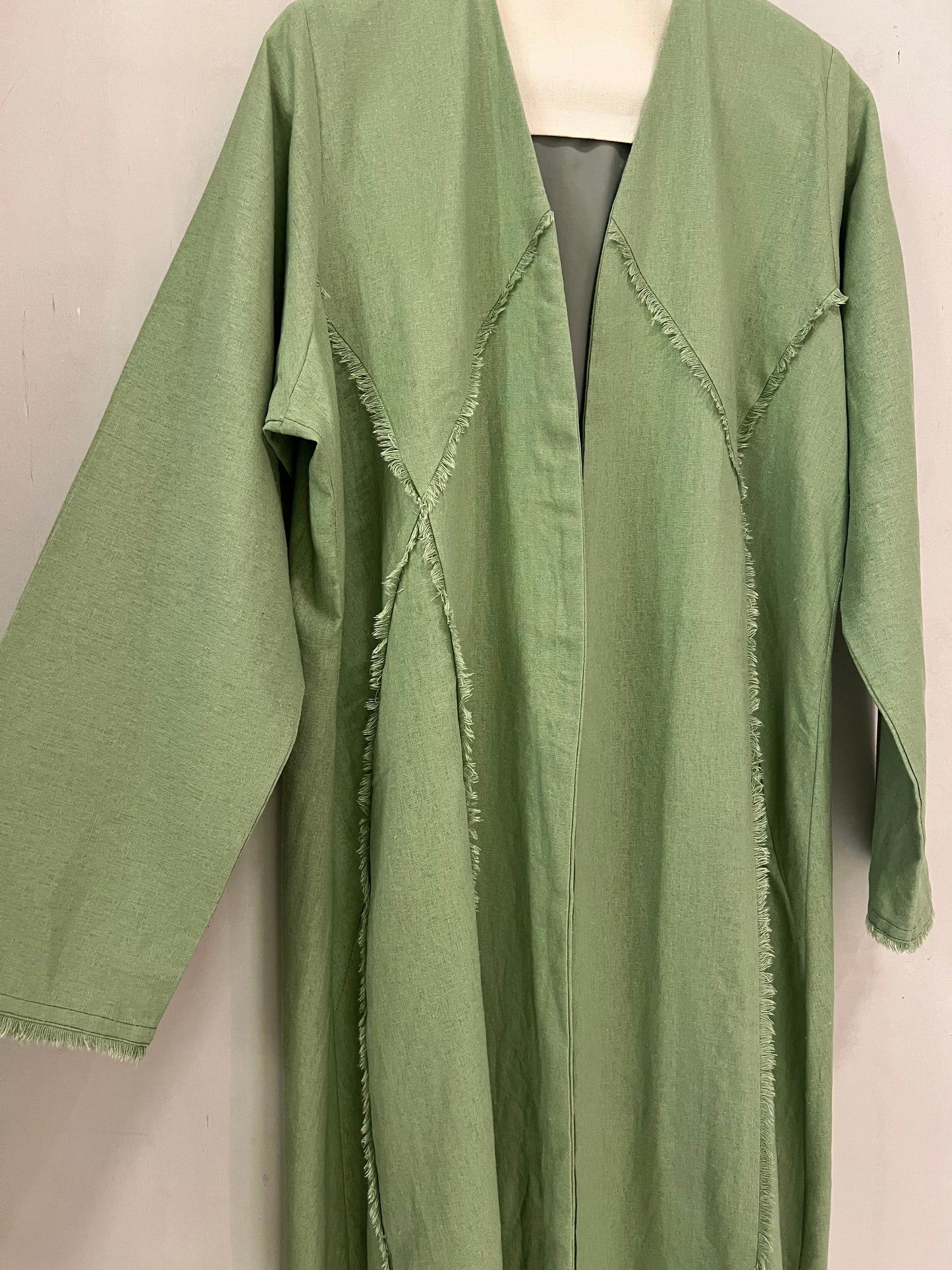 Abaya - Sage green features a contemporary minimalist design with artistic raw-edge detailing