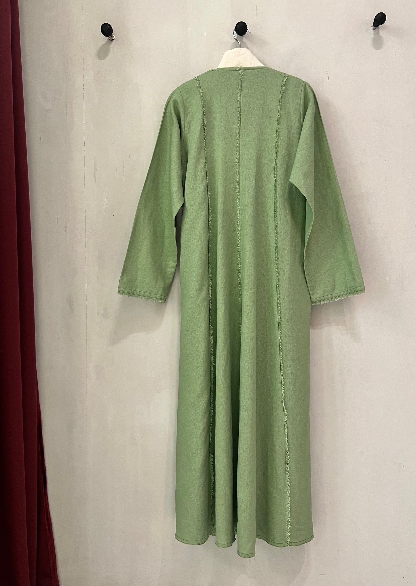 Abaya - Sage green features a contemporary minimalist design with artistic raw-edge detailing