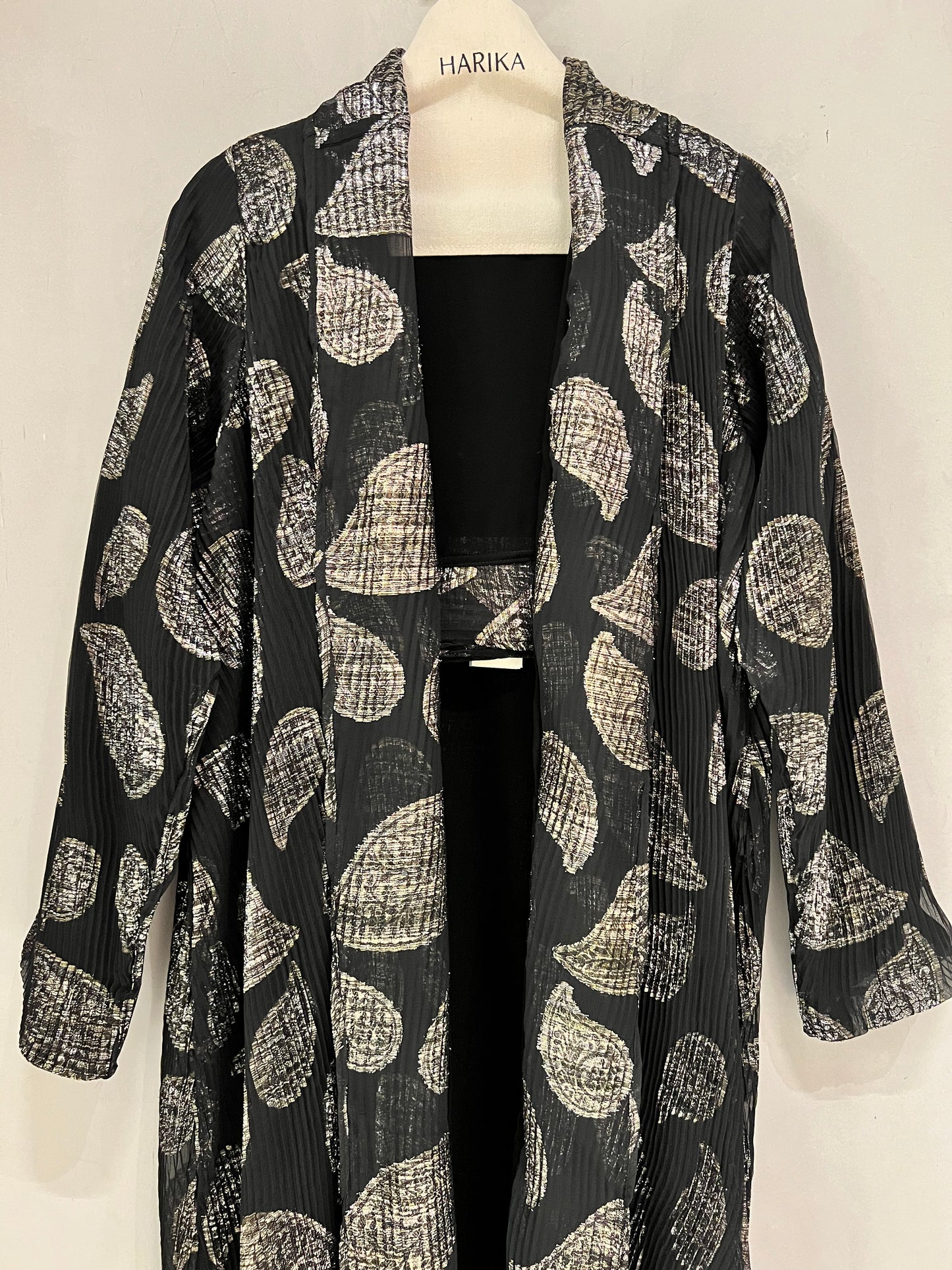 Abaya- a striking abstract leaf pattern in soft beige against a classic black backdrop