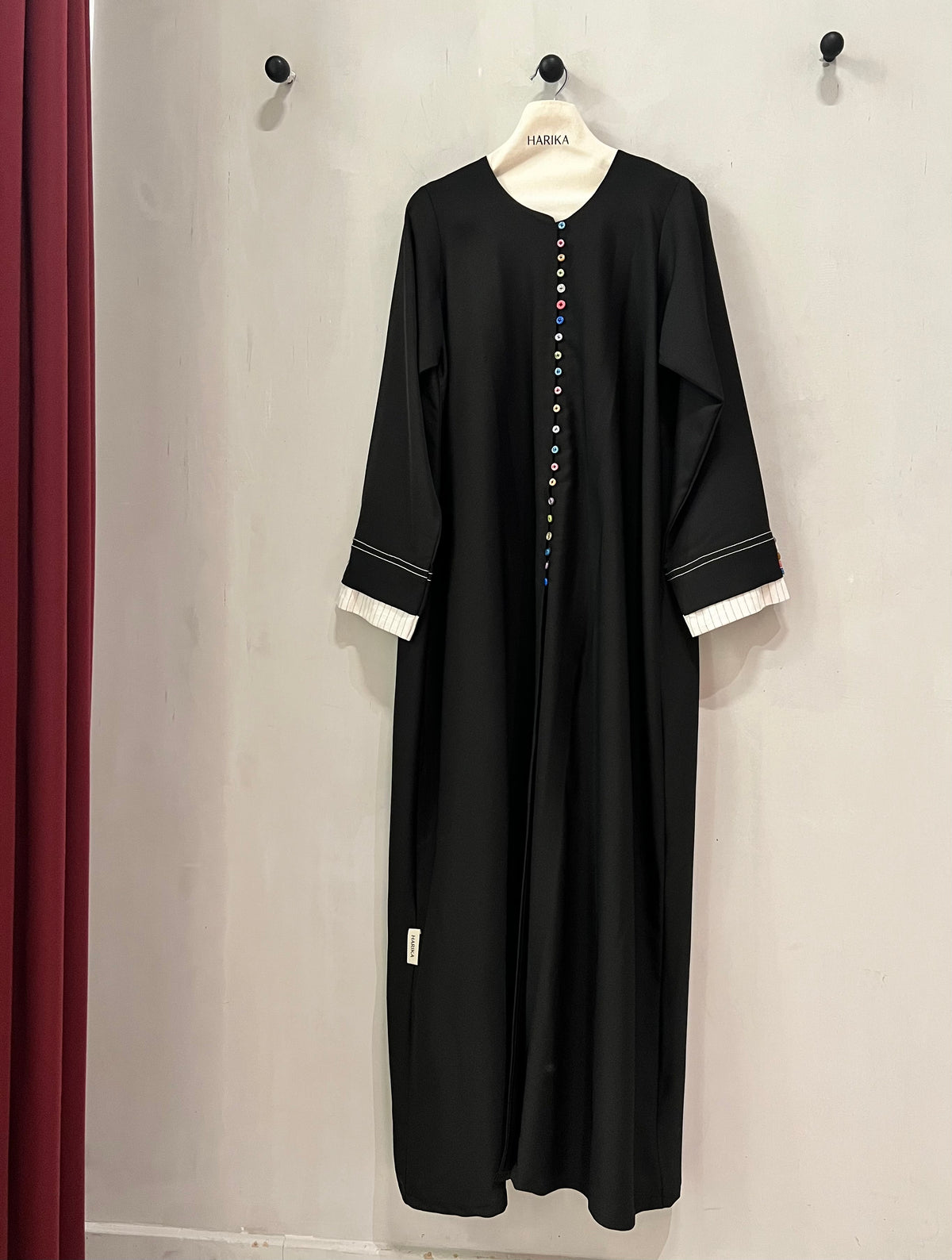 Abaya- A timeless black abaya with playful multicolor button detailing, designed for a modest yet stylish look.