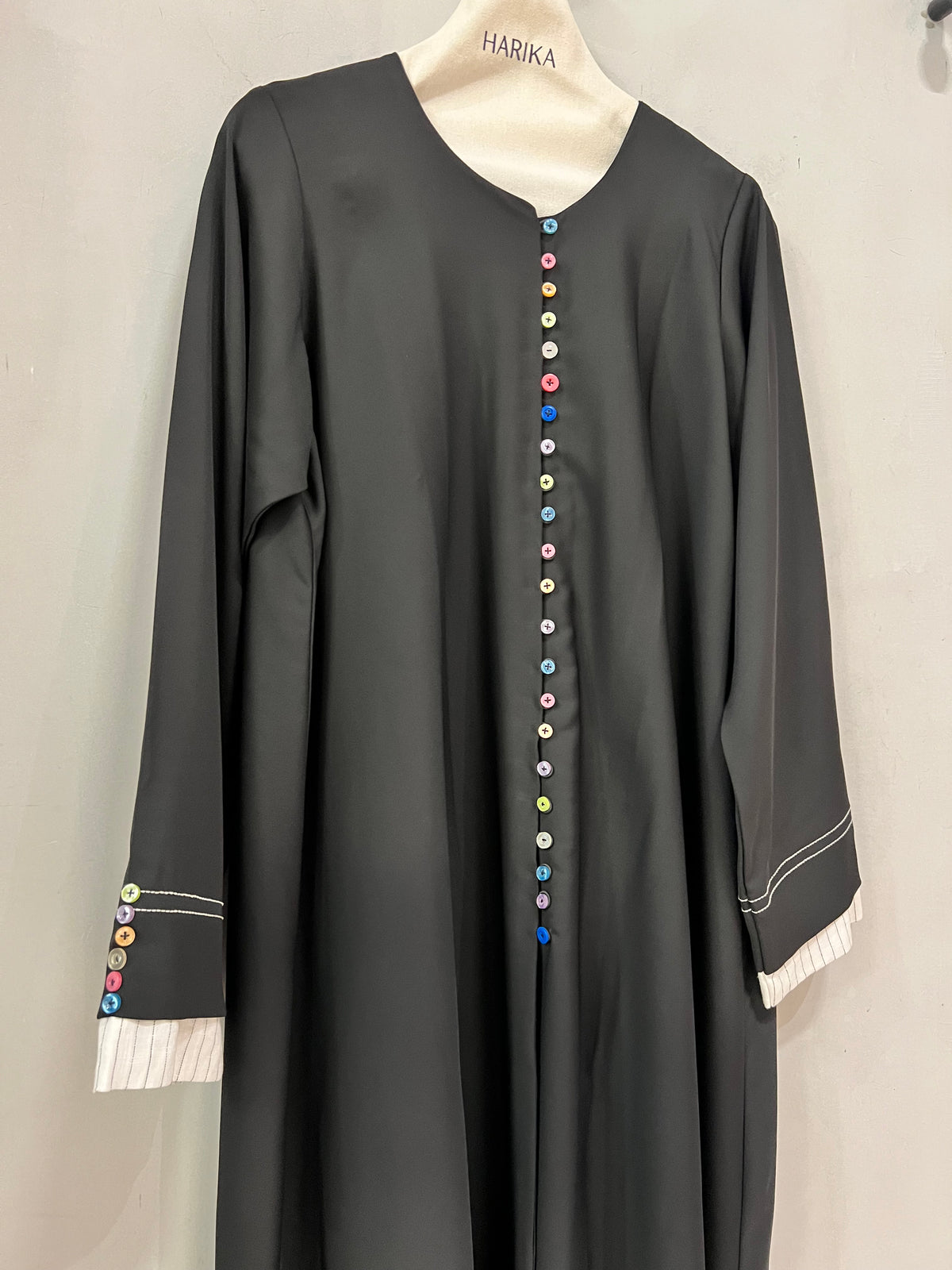 Abaya- A timeless black abaya with playful multicolor button detailing, designed for a modest yet stylish look.